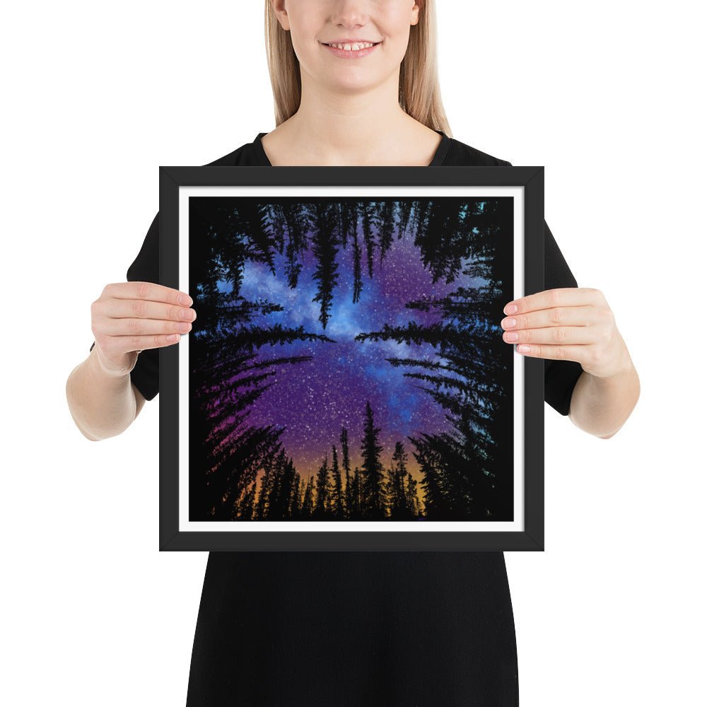 Model holding the Forest Nebula framed wall art poster with original hand-drawn night sky and forest illustration by Brittyliz for size context, comes ready to hang