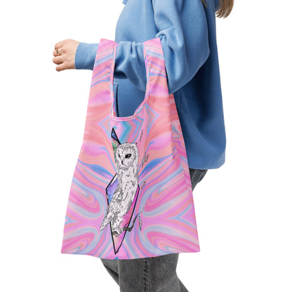 Front view of Mystical Owl Shopping Bag with hand-drawn white barn owl on pink and blue swirl all-over print by Brittyliz Art with a model carrying it over one arm.