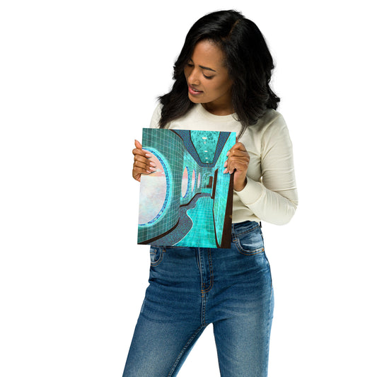 A woman holding a square canvas print featuring an abstract teal, turquoise, and gray design, wearing a cream long-sleeve top and blue jeans against a plain white background.