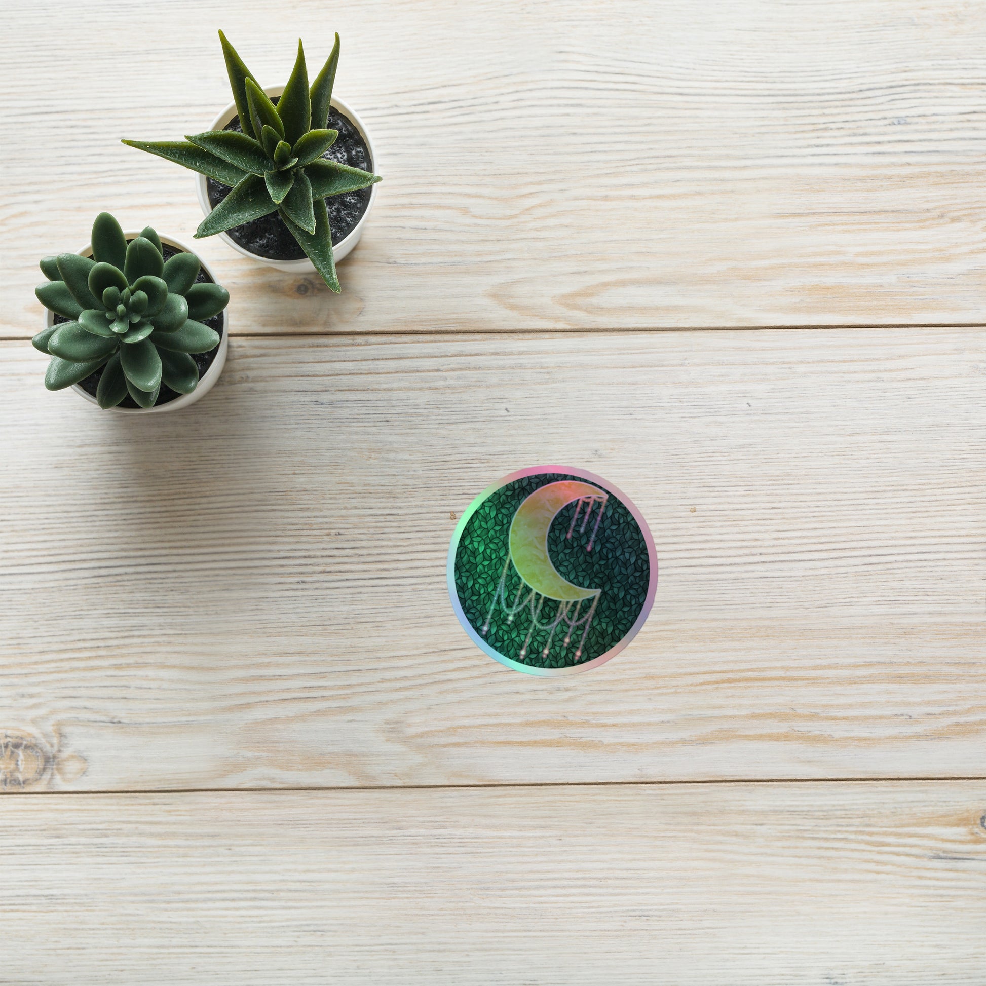 Druzy Moon holographic sticker 3x3 inch – hand-drawn crescent moon with jewel drips on a dark leafy background, rainbow holographic border, by Brittyliz Art