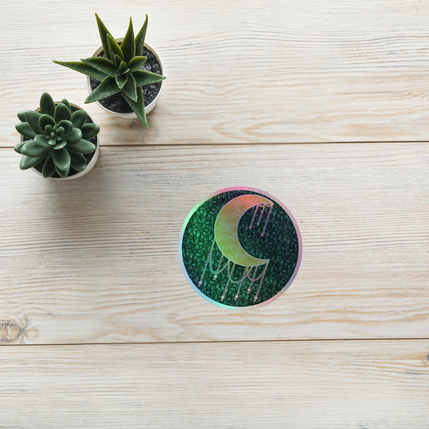Druzy Moon holographic sticker 4x4 inch – hand-drawn crescent moon with jewel drips on a dark leafy background, rainbow holographic border, by Brittyliz Art